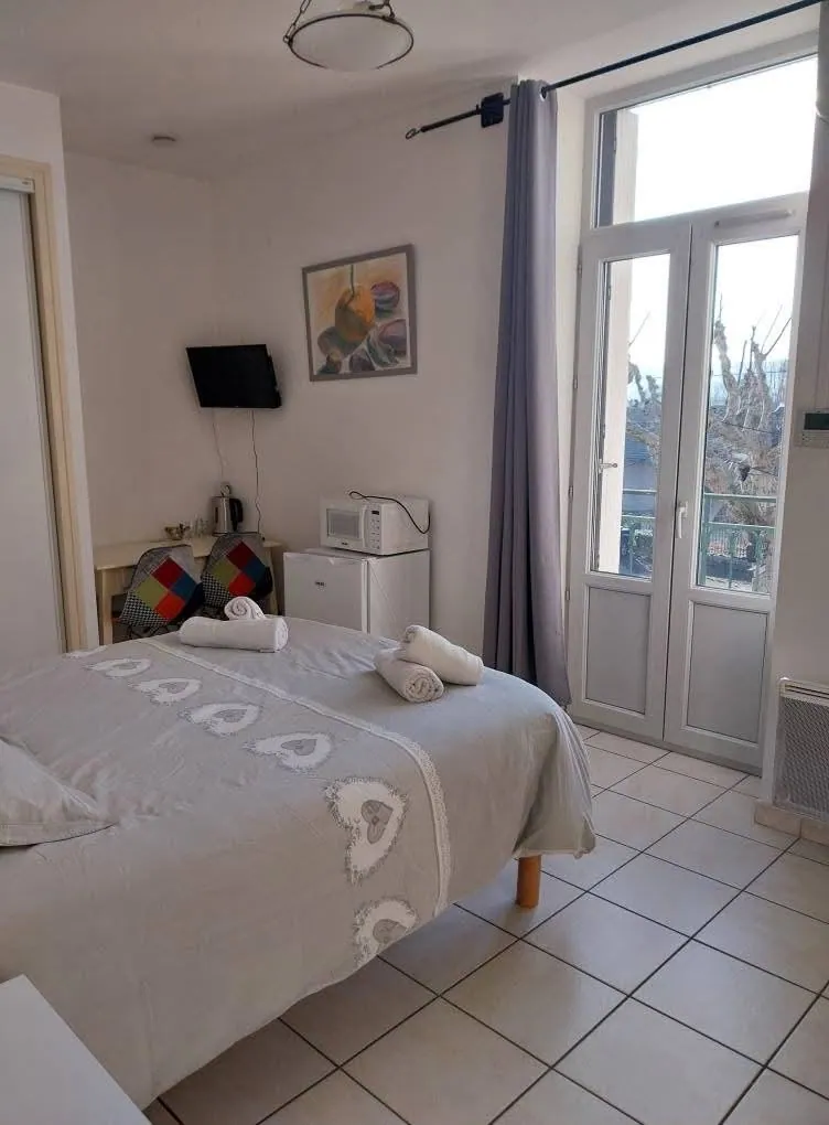 Chambre 2 : lit double et porte-fenêtre ouverte sur le balcon