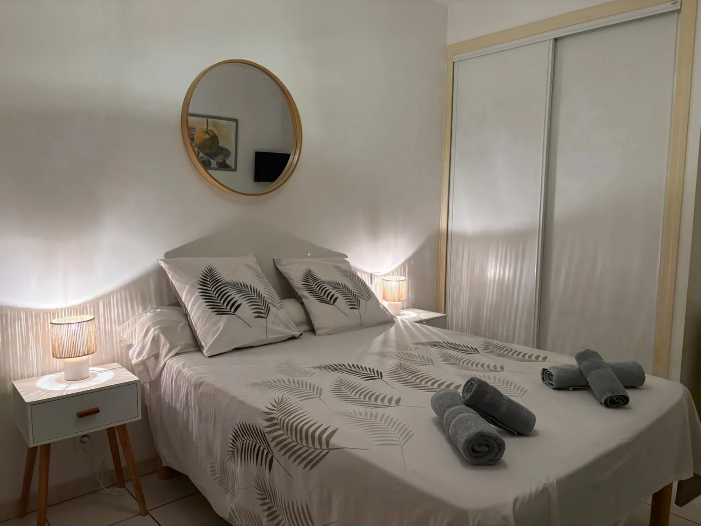 Chambre 2 du Café Arnaud à Ruoms : lit double, miroir rond et table de chevet