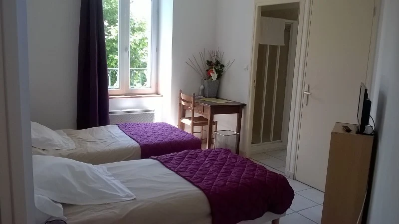 Chambre du Café Arnaud avec deux lits et bureau, côté cour
