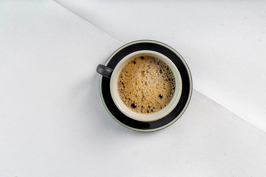 Une tasse d'expresso servie sur sa soucoupe, le premier café du matin