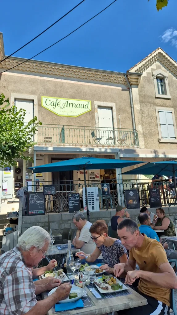 Clients attablés en terrasse devant le Café Arnaud à Ruoms